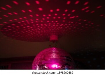 close up of a pink disco ball in a club