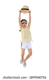happy asian little girl wearing sunglasses and lift up straw hat jumping on white isolated background. summer and fashion concept