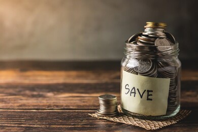 savings deposit coins in a clear glass bottle.
