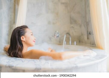 portrait beautiful young asian woman relax take a bath in bathtub in bathroom interior