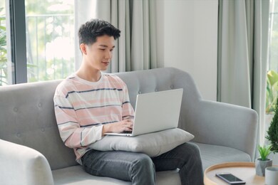 young man relaxing on the sofa with a laptop