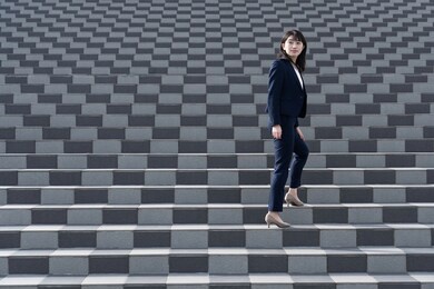 japanese woman in a suit walking on the stairs
