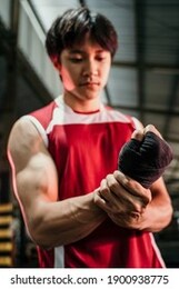 ultimate asian fighter getting ready, muscled asian fighter wearing black strap on wrist