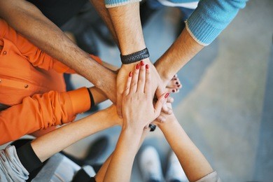 closeup of stack of hands. young college students putting their hands on top of each other symbolizing unity and teamwork.