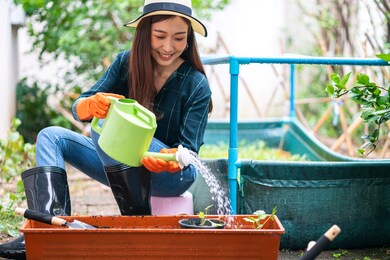 portrait of asian woman gardening her home vegetable garden at home