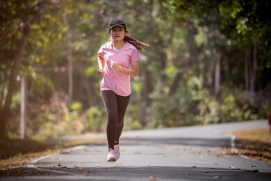 asian woman runner running in the morning tropical forest trail. concept nature and sport lifestyle.