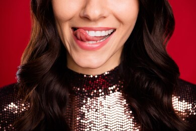 close up cropped portrait of satisfied lady tongue out licking lips teeth isolated on red color background