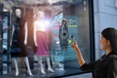 smart retail, shopping online technology concept, woman try to use smart display with virtual or augmented reality in the shop or retail to choose select ,buy cloths and give a rating of products 
