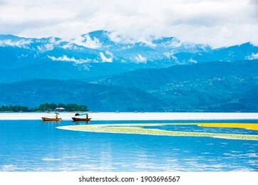 qionghai scenic area, xichang city, sichuan, china. people ride a boat with oars on the lake.