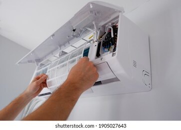 maintenance of the air conditioner. a technician is cleaning the filter. view of the hands.