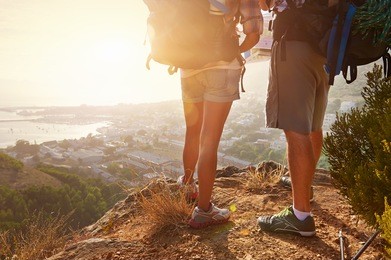 cropped image of two hikers legs standing on a hiking path and looking at the view