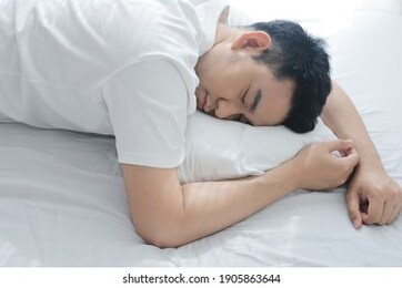 handsome asian man deep sleeping on bed.