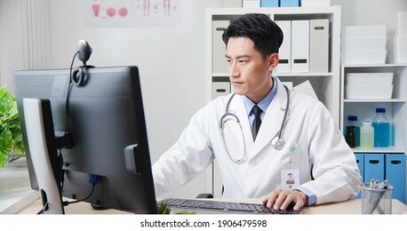 asian young doctor work and type something in computer at the clinic