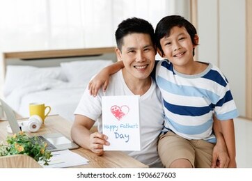 asian family i love you, dad! handsome man at home with his little boy. happy father's day. concept greeting card