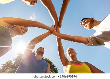 fitness, sport, friendship and healthy lifestyle concept - group of happy teenage friends in circle making high five