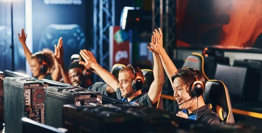 celebrating success. team of happy proffesional cyber sport gamers giving high five to each other while participating in esports tournament
