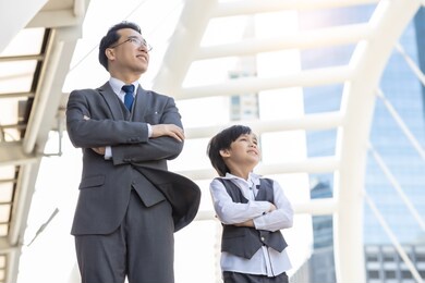 business father and son arms crossed and look at city with proud and confidence child want to be like a his dad parent and young boy standing in city with cityscape background planning in future life