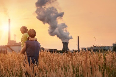 ecological concept image. father with son looking on chemical plant emissions at sunset time