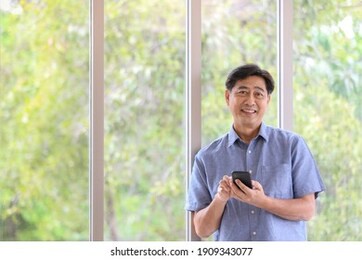 a senior man learning how to use the smartphone with happiness and a positive attitude. idea for a lifestyle of older people with modern communication technology.