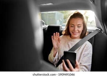 transport, vehicle and technology concept - happy smiling woman or female passenger in taxi car having video call on smartphone