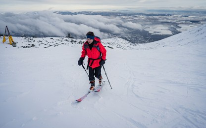 ski touring man in high alpine landscape with snowy trees. ski touring in spectacular mountains. winter vacations, active lifestyle, skiing and trekking concept.