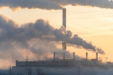 environmental problem of pollution of environment and air in cities. smoking industrial zone factory chimneys. view of large plant with smoking pipes