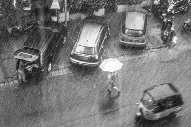 a woman rushes to cross the street under a heavy rain in jakarta, the capital city of indonesia