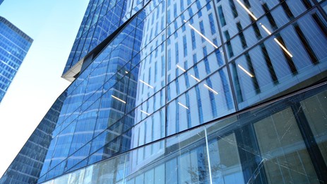glass facade of the buildings with a blue sky. skyscrapers in the business city center.. background of modern glass buildings. 