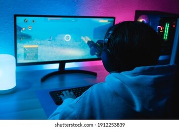 girl playing shooter online video game - technology trend concept - main focus on headphones