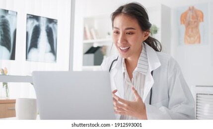 asian female doctor using laptop computer online video call remote talking to patient