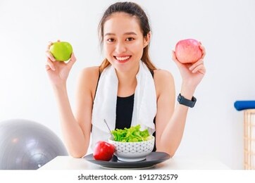 beautiful asian woman healthy blogger is showing fruit and clean diet food. in front of the camera to recording vlog video live streaming at home.fitness influencer on social media online.