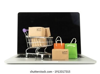 paper boxes in a trolley and shopping bag on laptop computer on white background,online shopping or ecommmerce concept