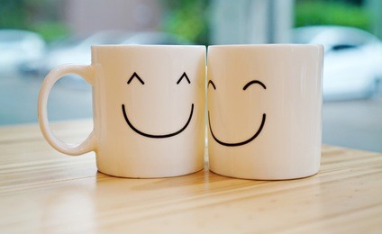 two happy cups with black polka dot tablecloth. concept about love and relationship