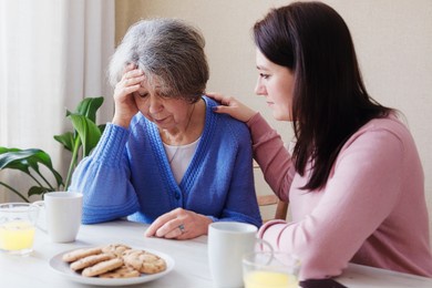 daughter consoles an elderly mother in illness - a pensioner woman has a bad diagnosis and is worried about her health - a volunteer visits an elderly woman when she is stressed