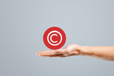 businessman hand holding a red badge with copyright symbol. property rights and brand patent protection.