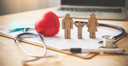 medical insurance concept with family and stethoscope on wooden desk