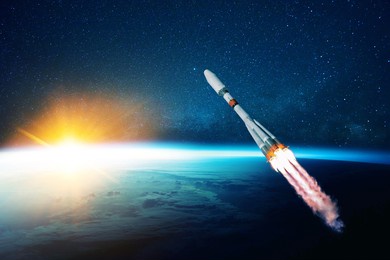 space rocket flies in the starry sky over the amazing blue planet earth and yellow sunset. spaceship with blast flies into outer space. travel to other planets concept. successful start