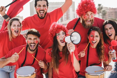 crazy football fans having fun outside stadium for soccer match - focus on center girl face