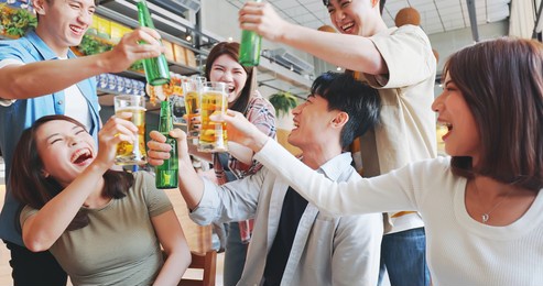 asian six friends watch ball games on tv and toasting beer in the restaurant