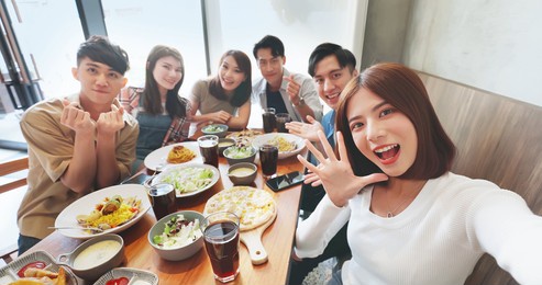 high angle shot of asian young six friends taking selfie in restaurant happily