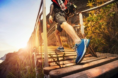men are hiking in the mountains, walking on a wooden bridge at sunset. healthy lifestyle.
