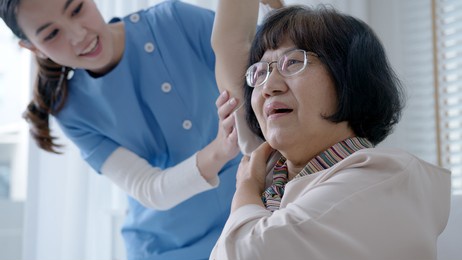 young senior asia citizen female with scrubs nurse physiotherapy worker at home in rehabilitation therapy service for aging parents. massage for older care, ache pain joints exercise in old people.