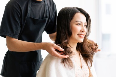 asian woman with happy expression doing hairdressing at salong