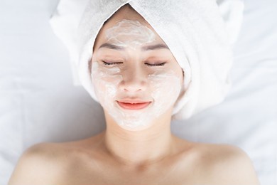 asian woman doing beauty treatments, spa treatments and being applied cream to her face