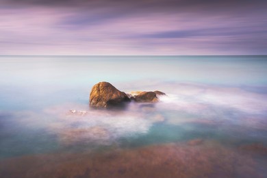 rocks, soft sea and clouds in the sky, beautiful landscape in long exposure photography. castiglioncello, tuscany, italy.