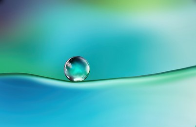 beautiful clean bright drop of water on smooth surface in blue and turquoise colors, macro. creative image of beauty of environment and nature.