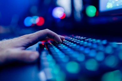 professional cyber video gamer studio room with personal computer armchair, keyboard for stream in neon color blur background. soft focus.
