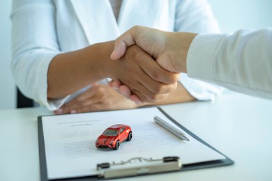 insurance agent joins hands with the insured after proposing the concept of car insurance. and contract insurance concept agreement making rental and purchase agreements for cars