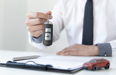 car dealers or insurance managers cover and protect against damage and the risk of driving, hold the car keys, protecting and after-sales care concept.