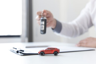 car dealers or insurance managers cover and protect against damage and the risk of driving, hold the car keys, protecting and after-sales care concept.